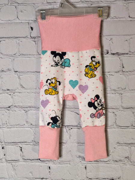 Front: White pants with pink and purple small hearts. Larger hearts of purple, teal and pink mixed in with baby Mickey and Minnie Mouse and Pluto. Soft pink waistband extended and leg bands extended for larger size